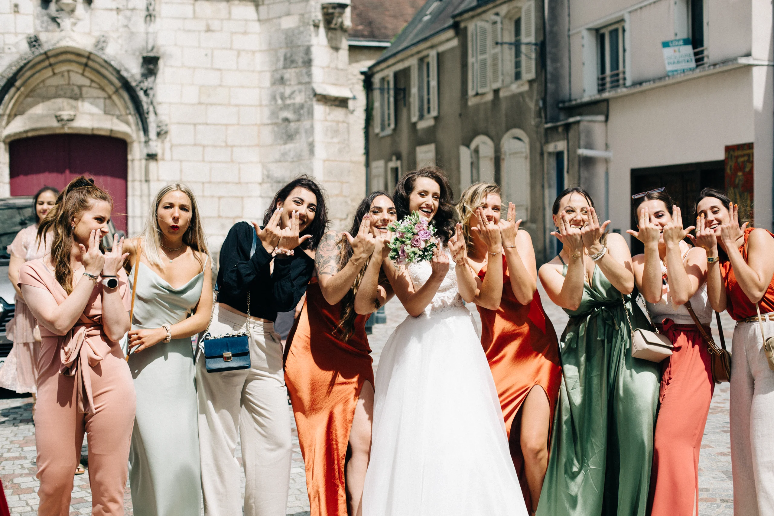 Demoiselles d'honneur en robes satinées envoyant des baisers à la mariée
