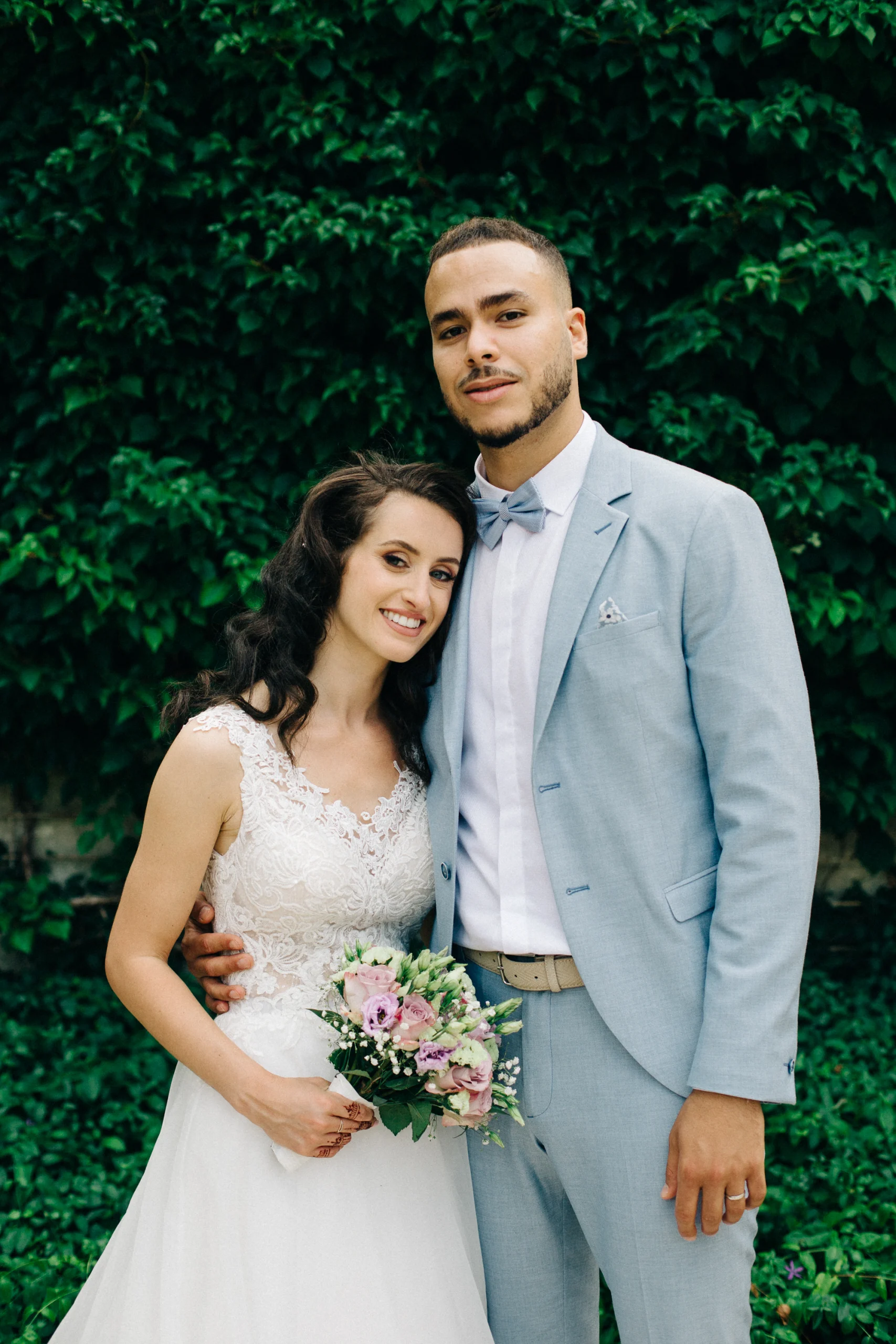 Portrait des mariés souriants devant un mur de lierre, mariage dans le Centre de la France