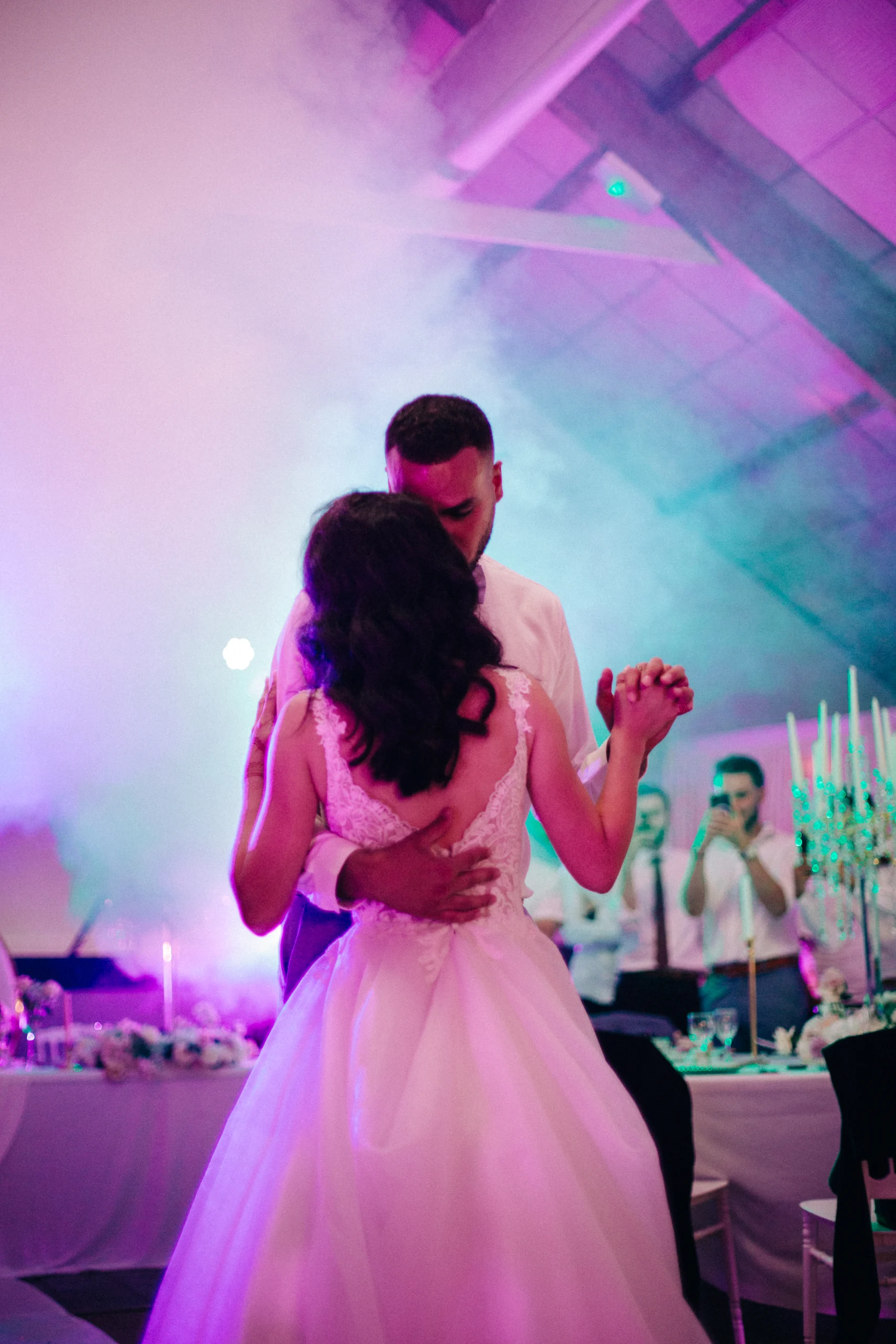 Première danse des mariés dans une salle baignée de lumière rose et violette, mariage à Bourges