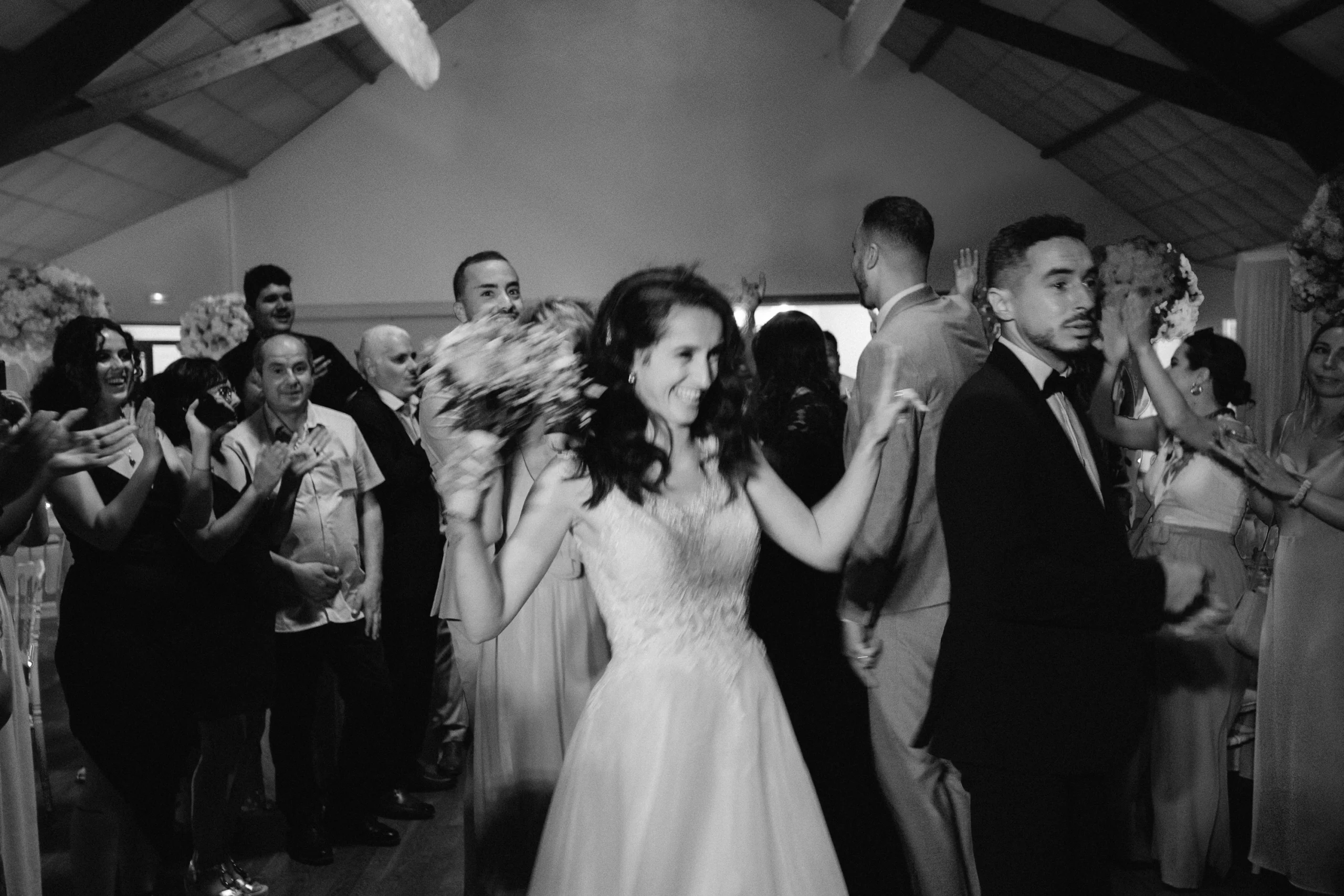Mariée dansant au milieu des invités, photo de mariage en noir et blanc