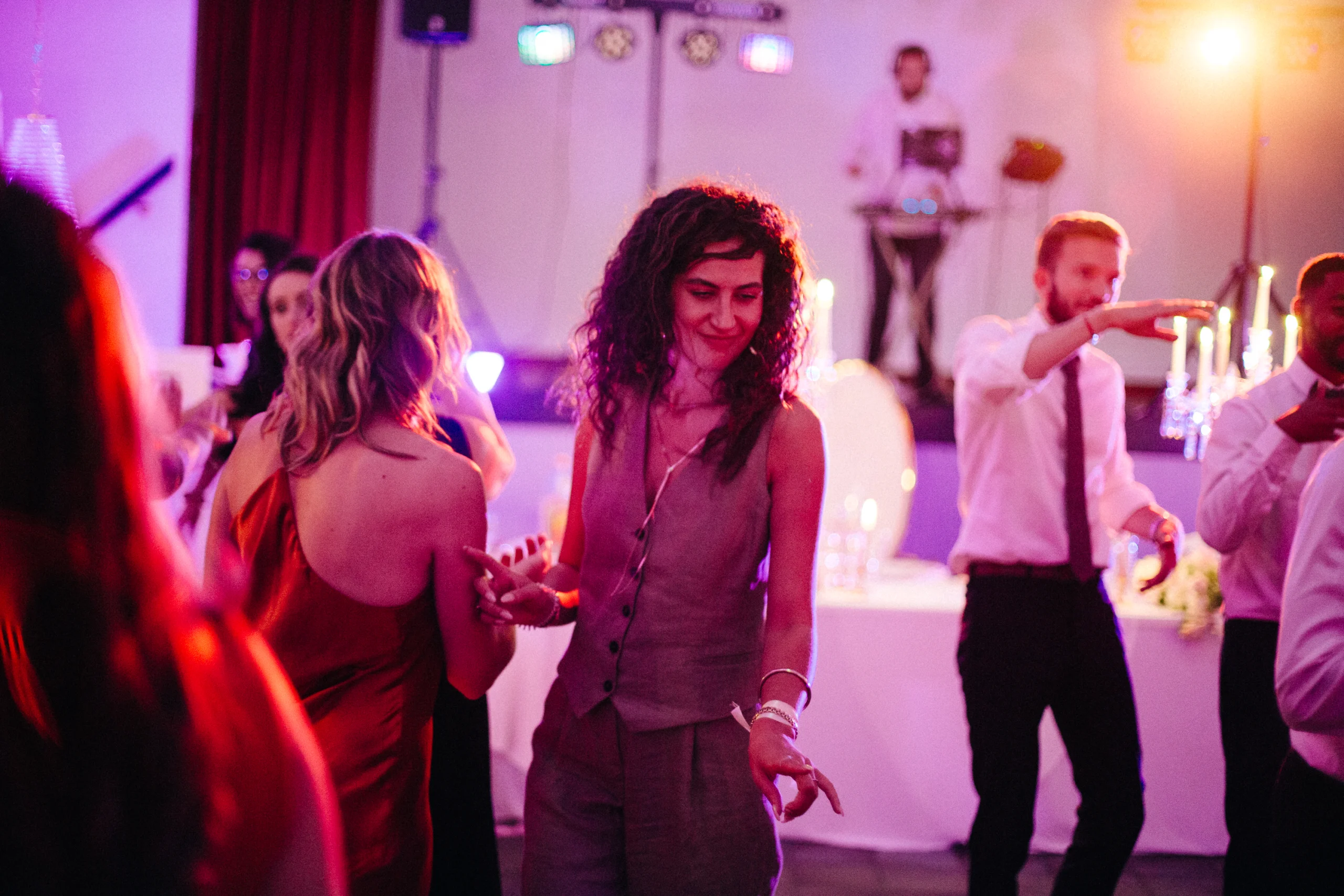 Invités dansant sous les lumières colorées de la soirée de mariage