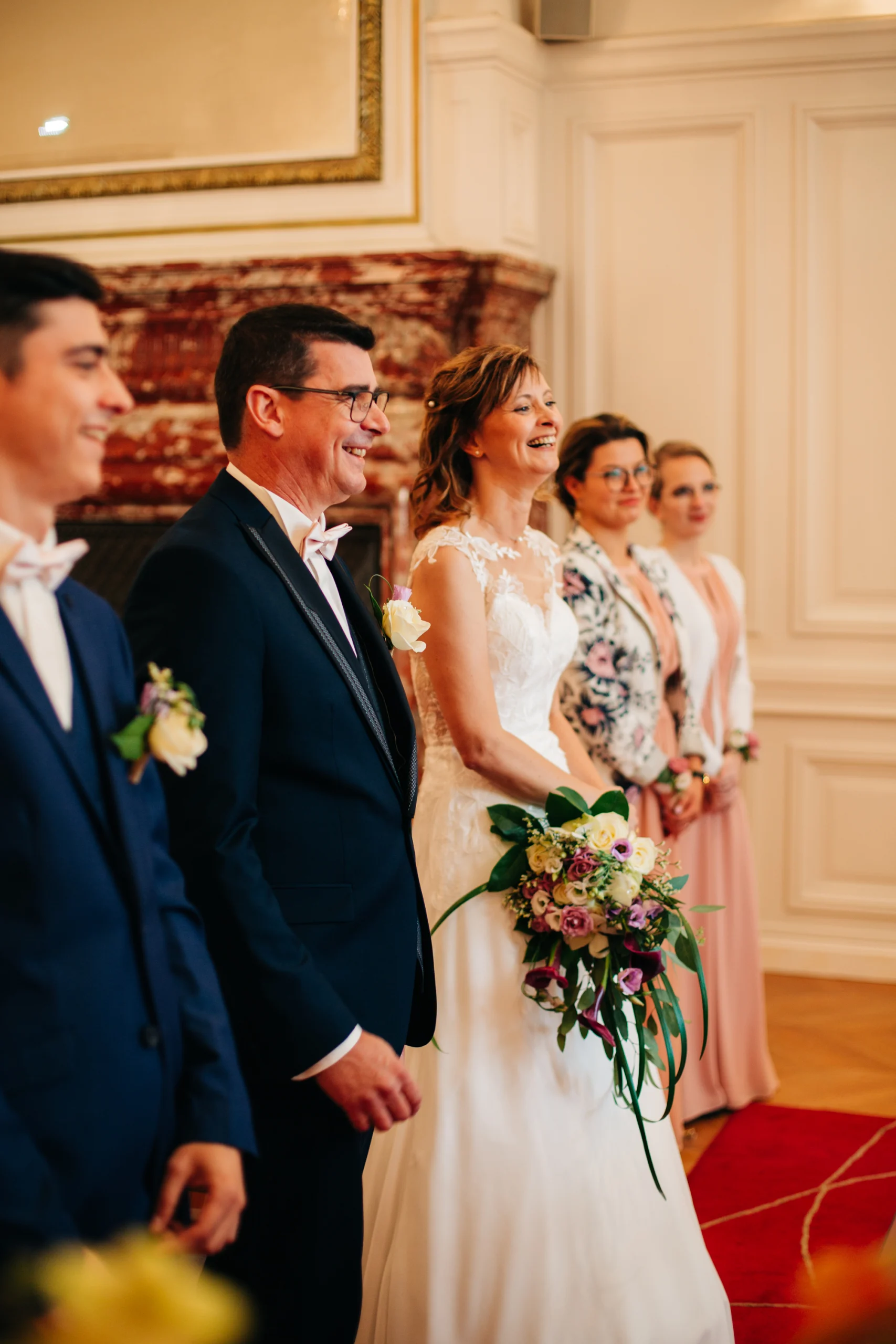 Mariés debout devant l'officier d'état civil, bouquet de fleurs à la main