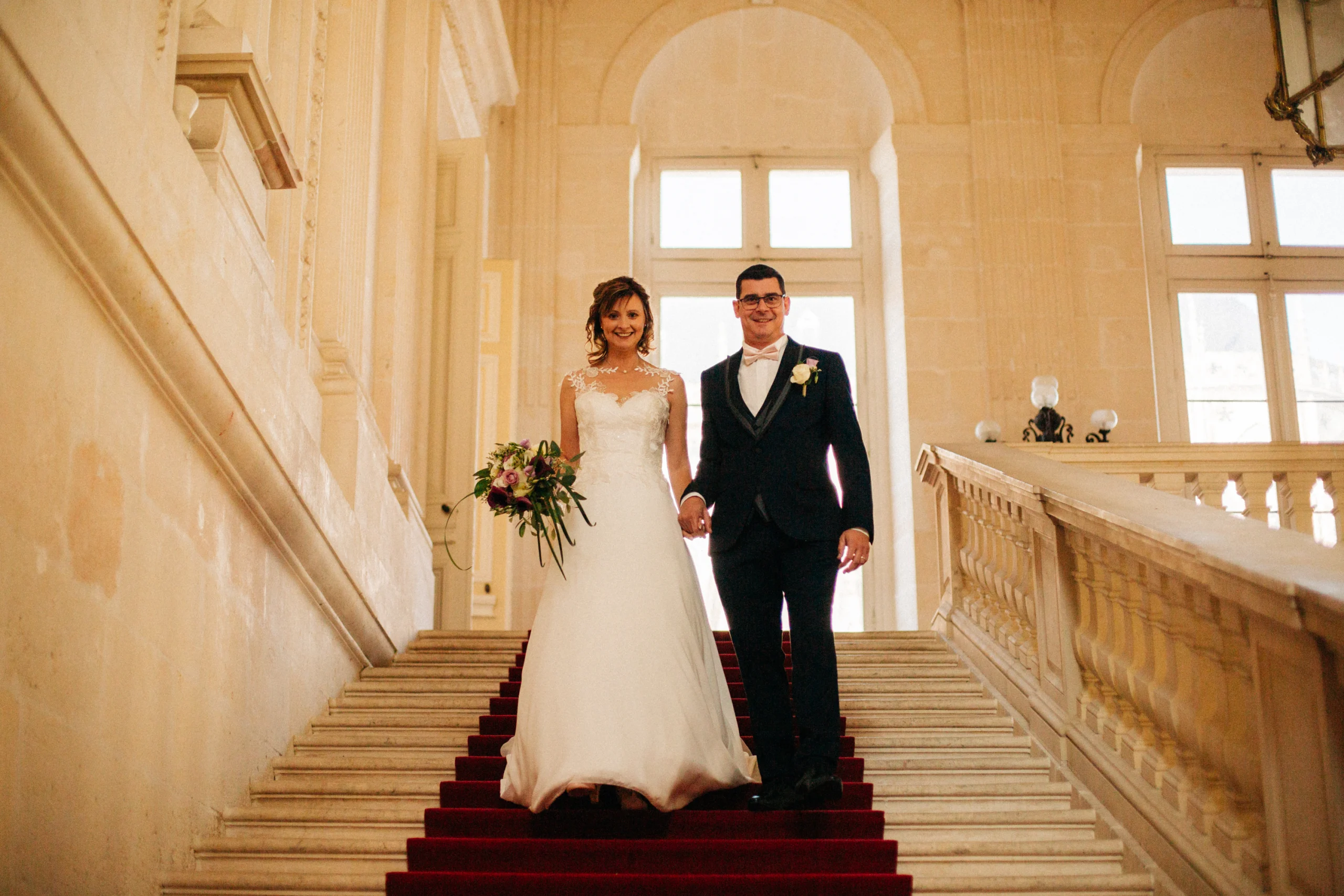Mariés descendant le grand escalier en pierre de la mairie de Bourges