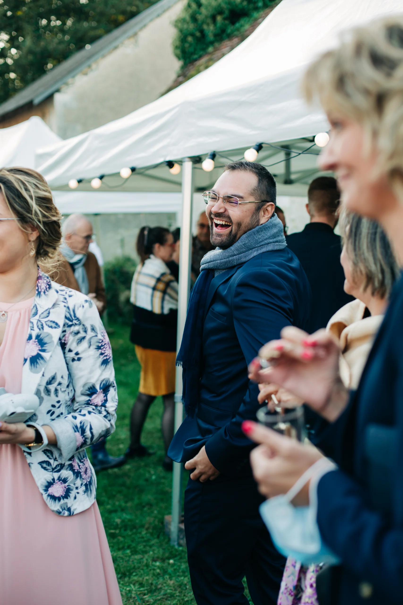 Invités riant ensemble pendant le vin d'honneur en plein air