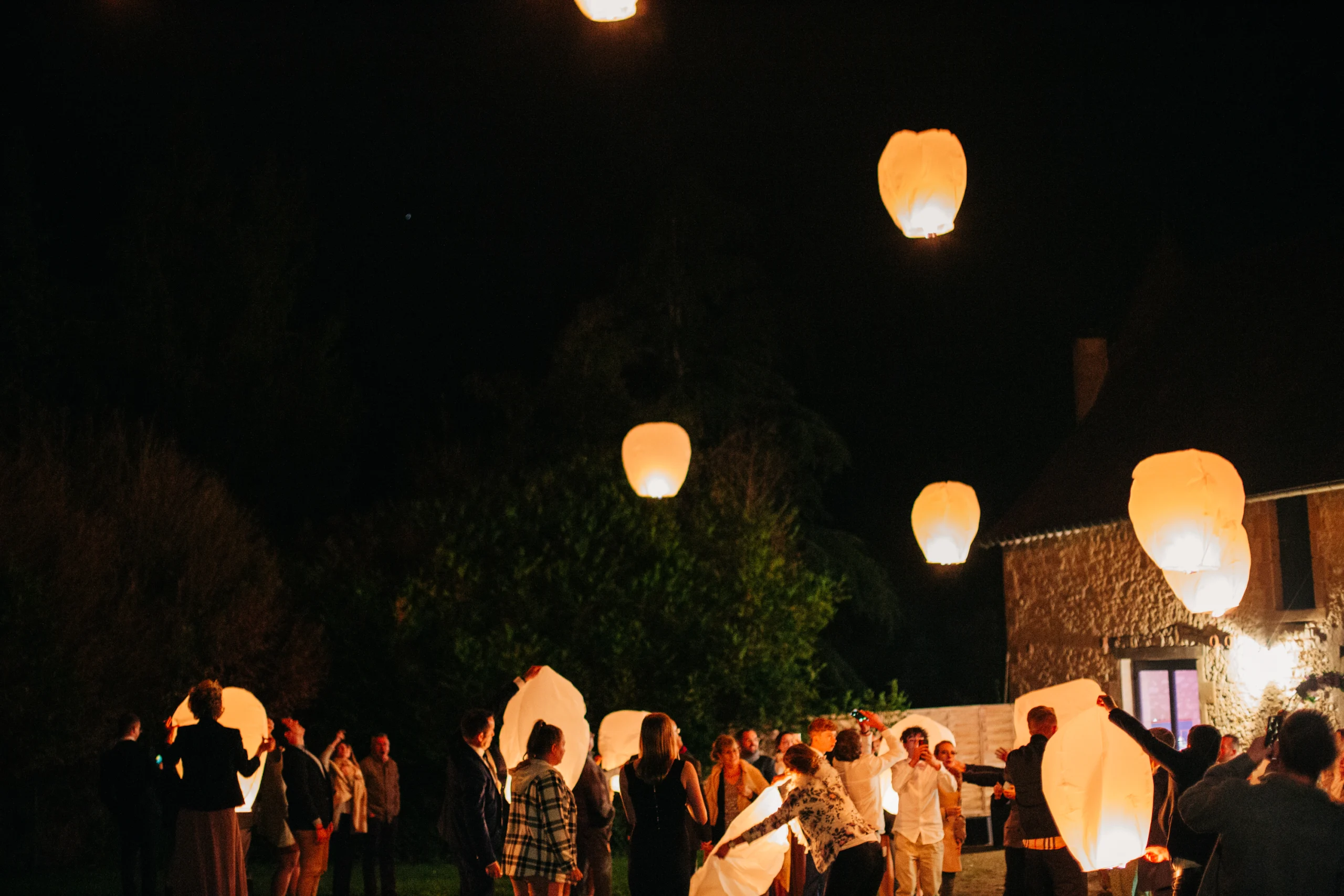 Lâcher de lanternes célestes dans le ciel nocturne pendant le mariage