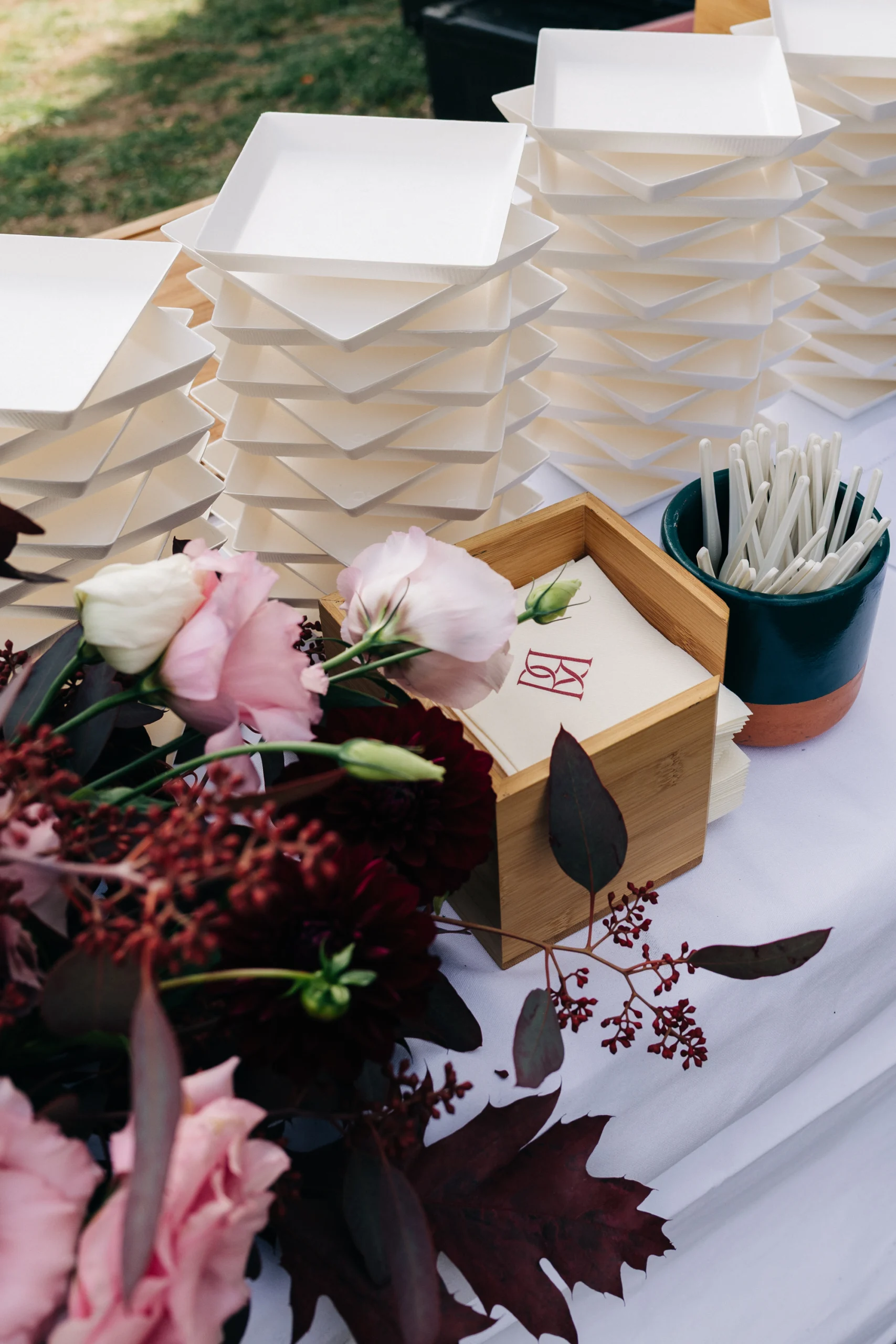 Buffet du traiteur décoré de fleurs roses et feuillages pourpres