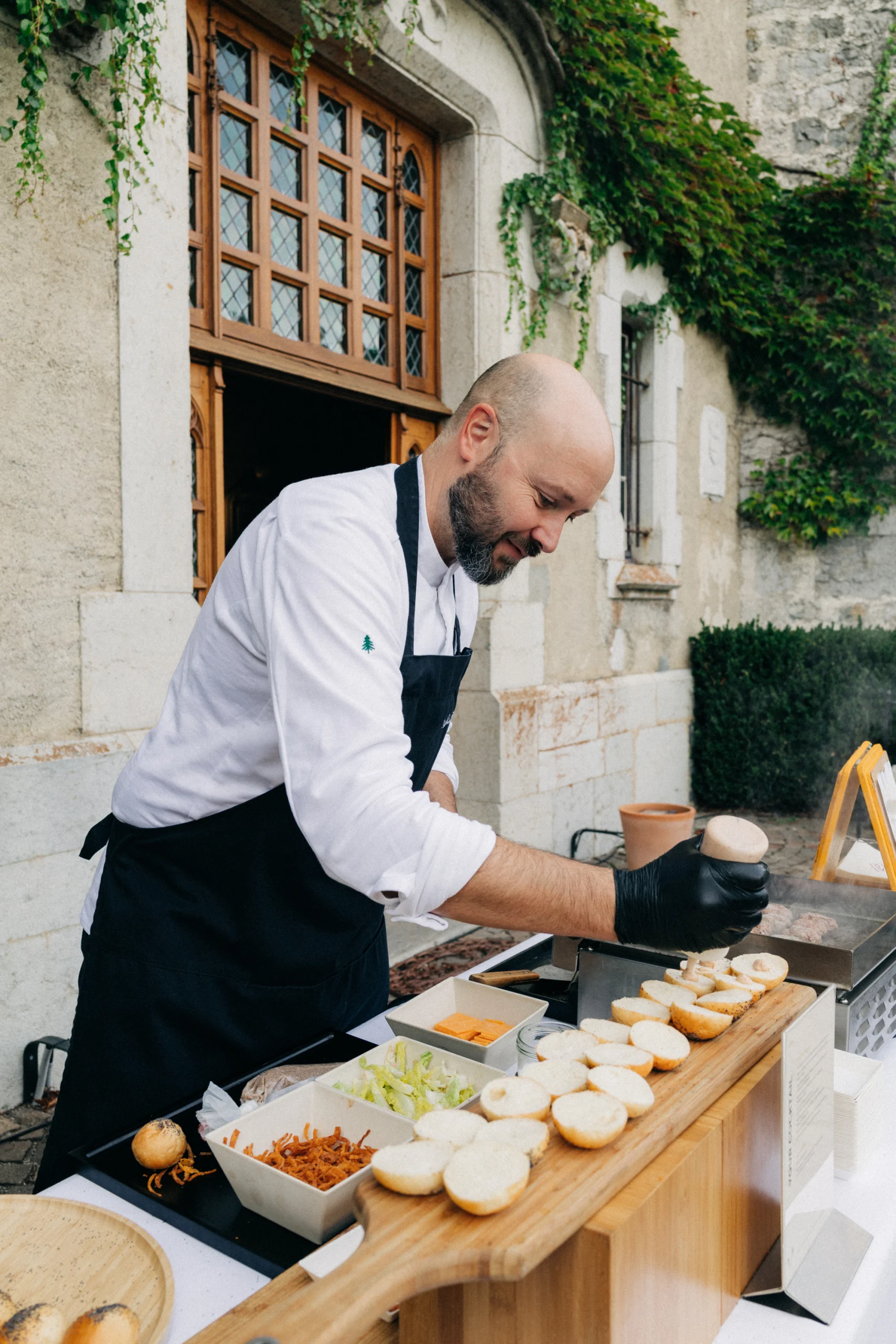 Chef du traiteur préparant des mini-burgers devant le Château de Thorens