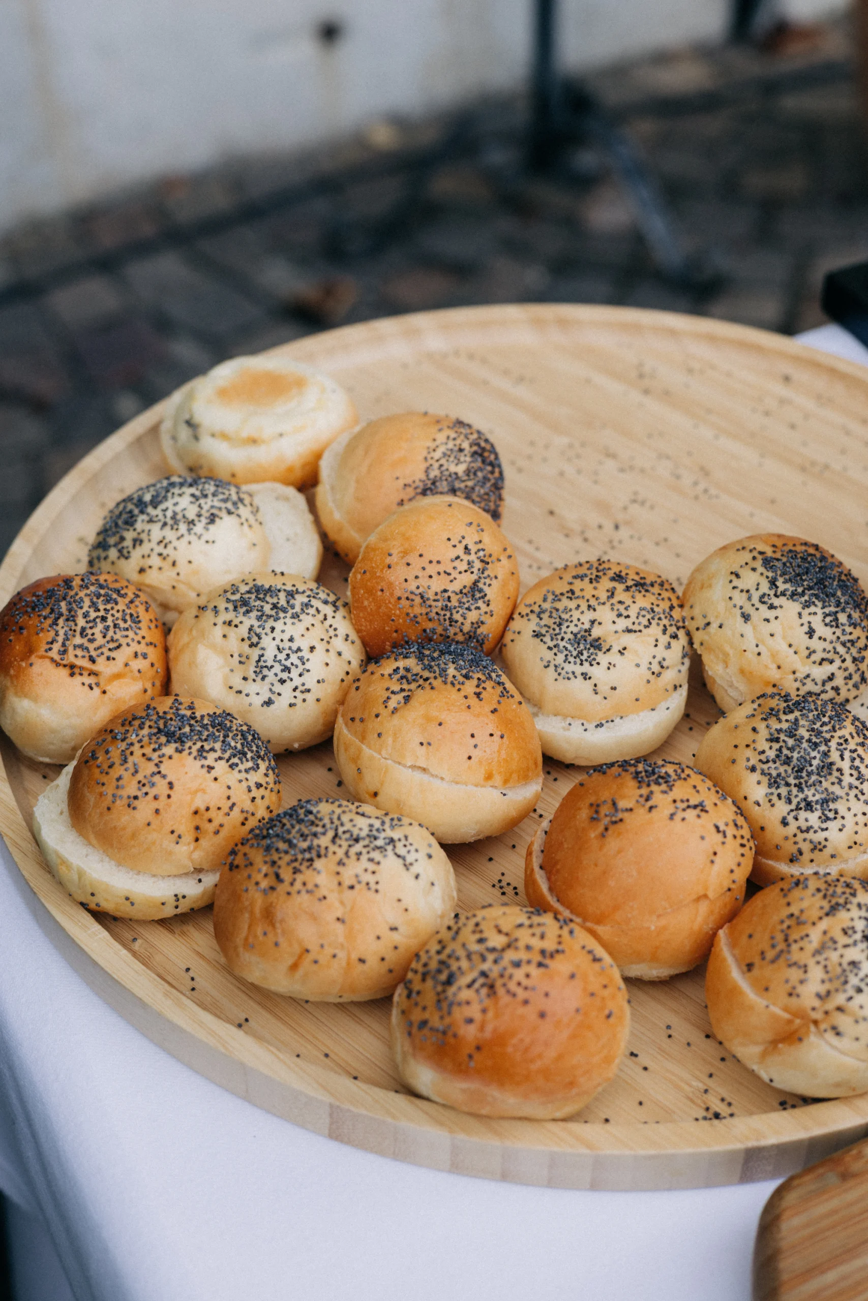Petits pains aux graines de pavot sur un plateau en bois, buffet de mariage