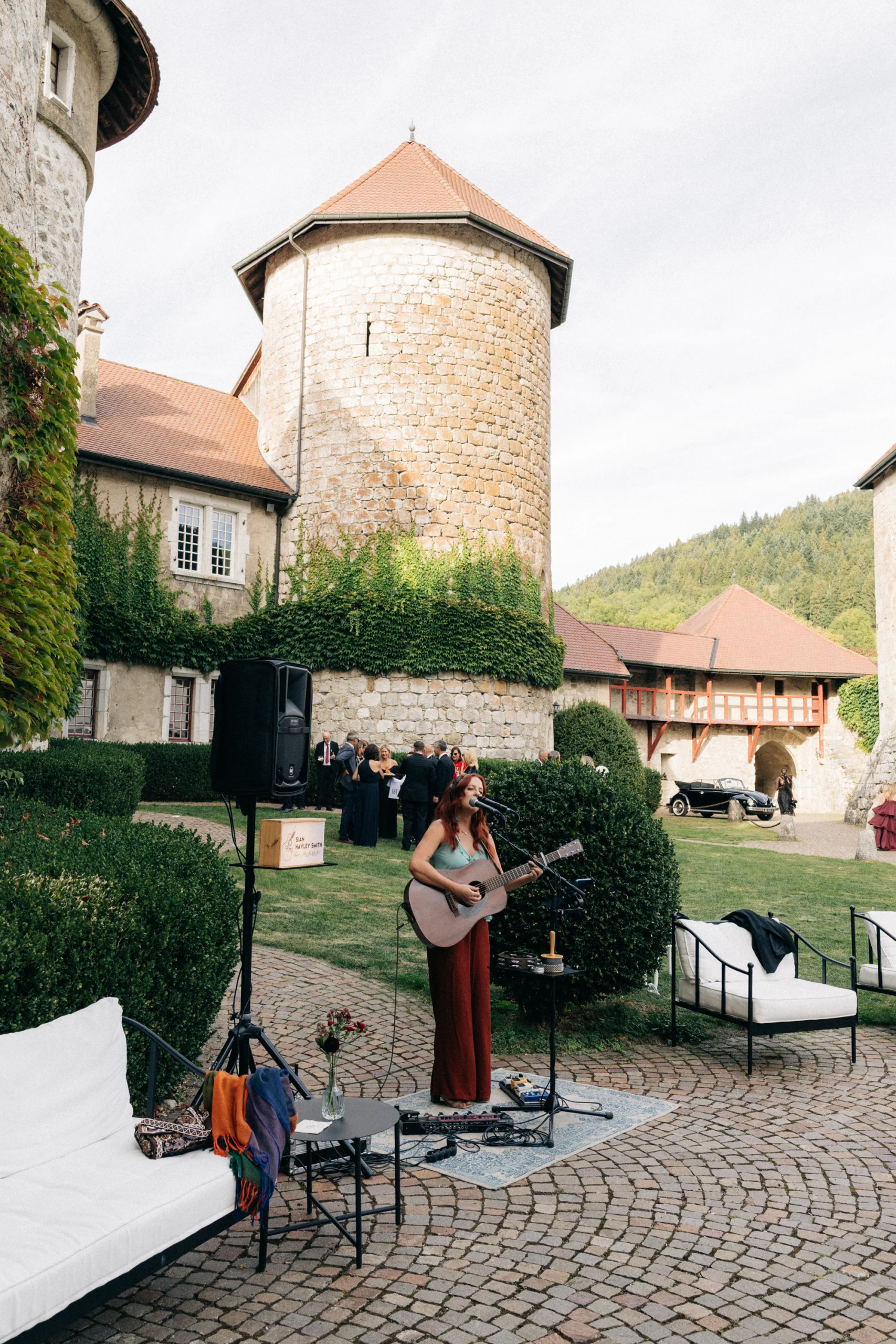 Musicienne jouant de la guitare dans la cour du Château de Thorens