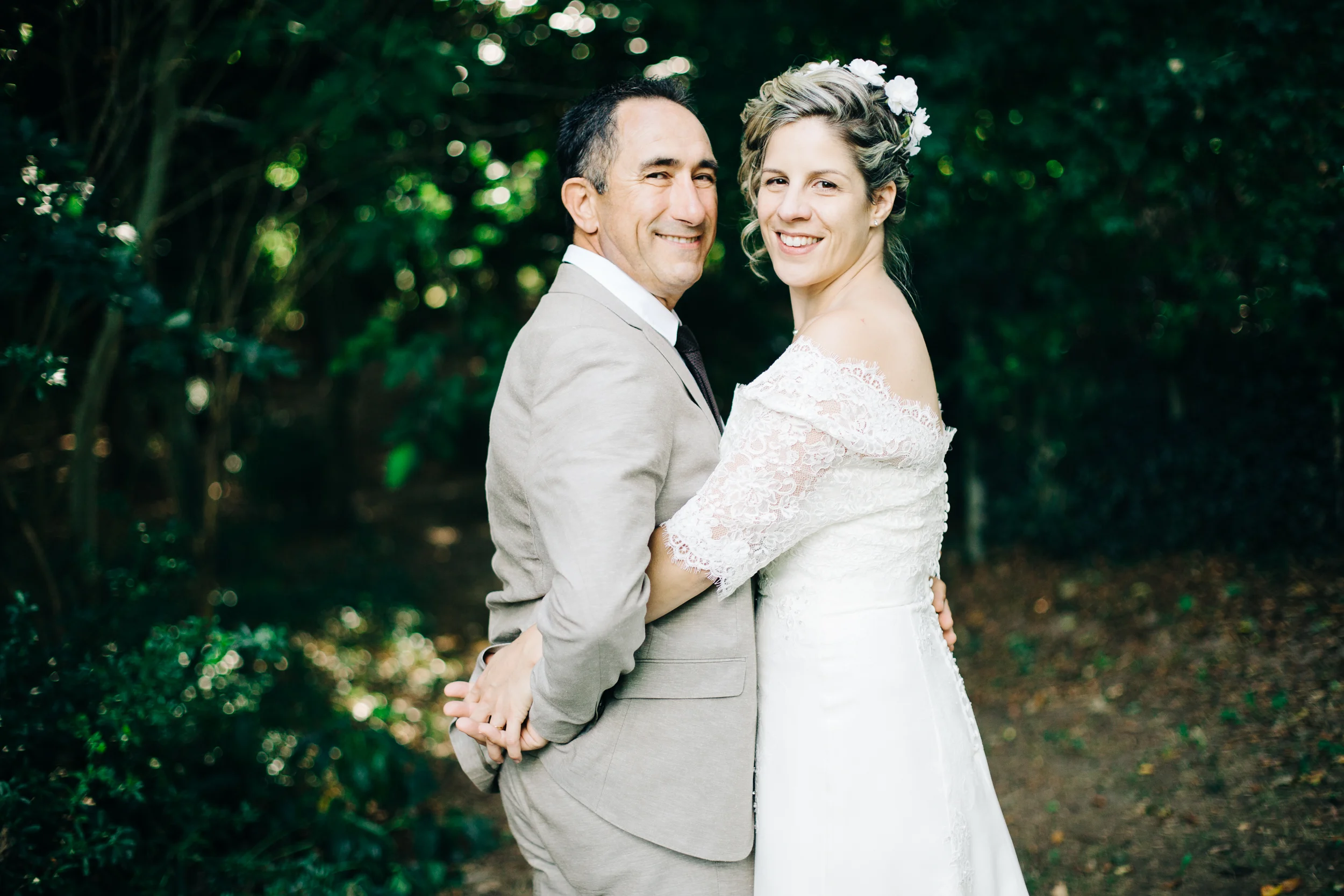 Portrait des mariés enlacés dans un jardin ombragé, mariage en Haute-Savoie