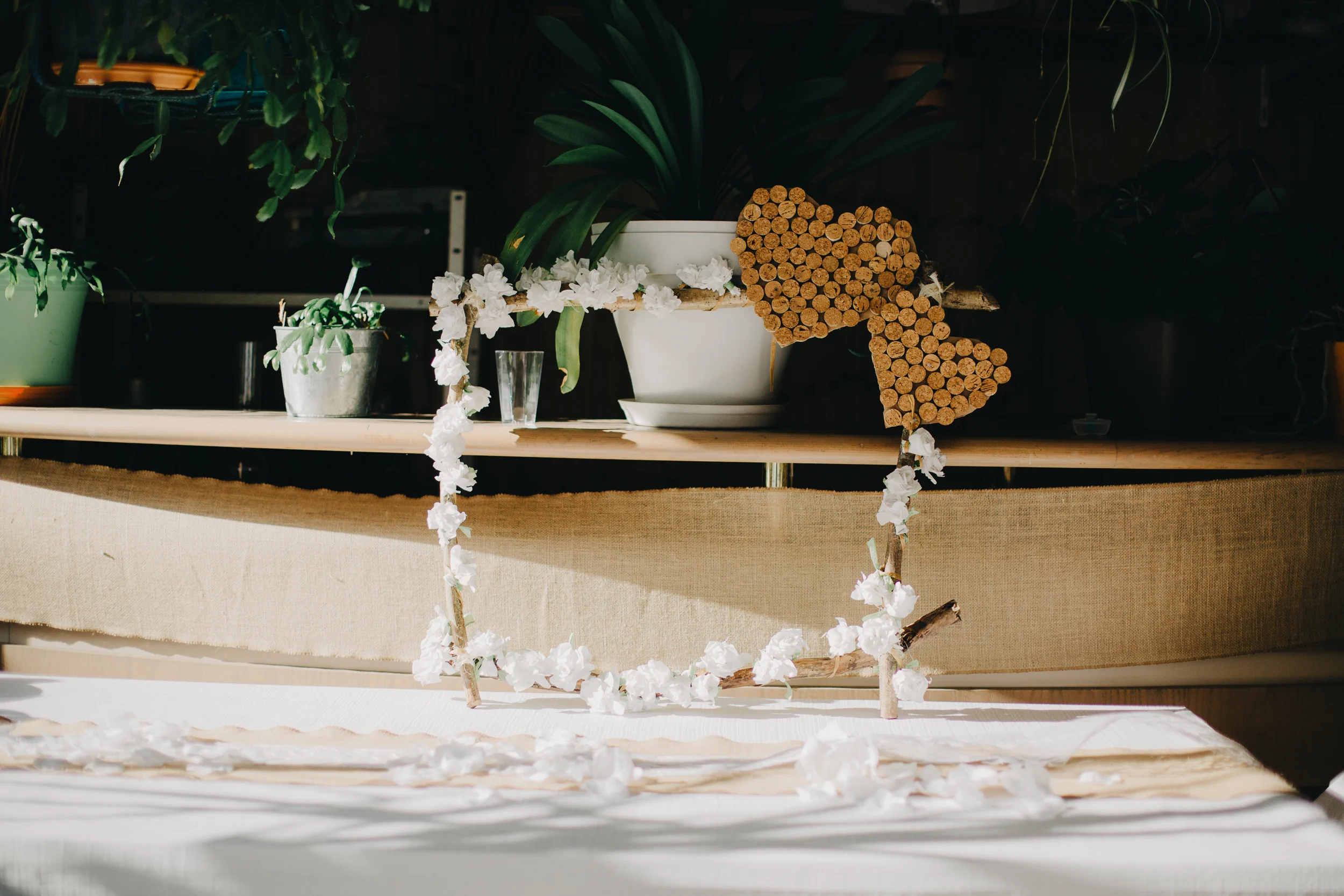 Décoration de table de mariage : cœurs en bouchons de liège et guirlande de fleurs blanches