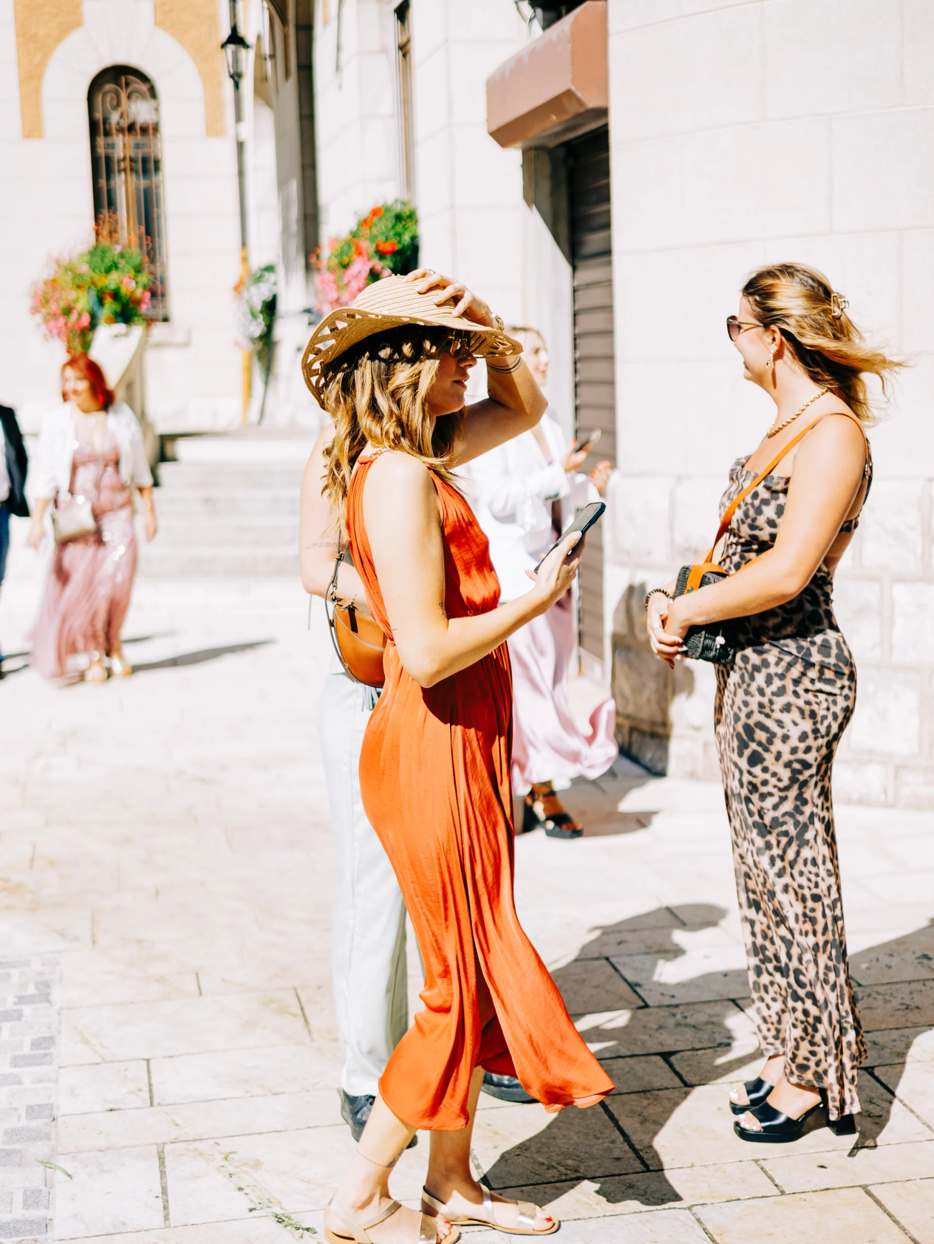 Invitées en robe orange et pantalon léopard à la sortie de la mairie de La Clusaz