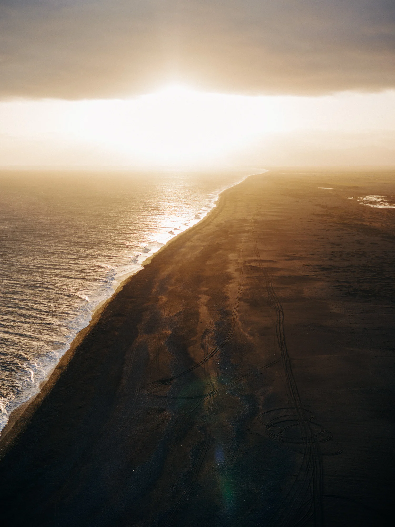 Plage de sable noir au coucher du soleil vue depuis Dyrhólaey, Islande