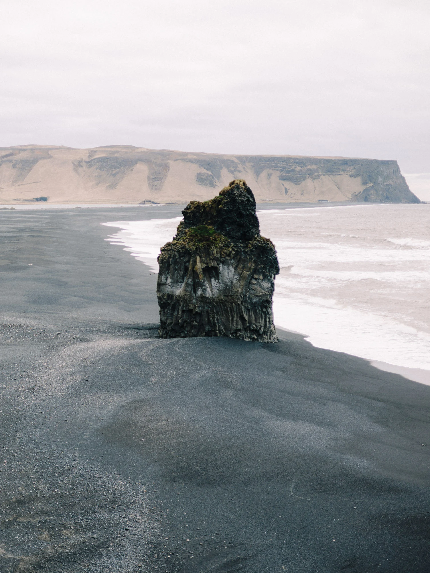 Rocher basaltique sur une plage de sable noir, Islande