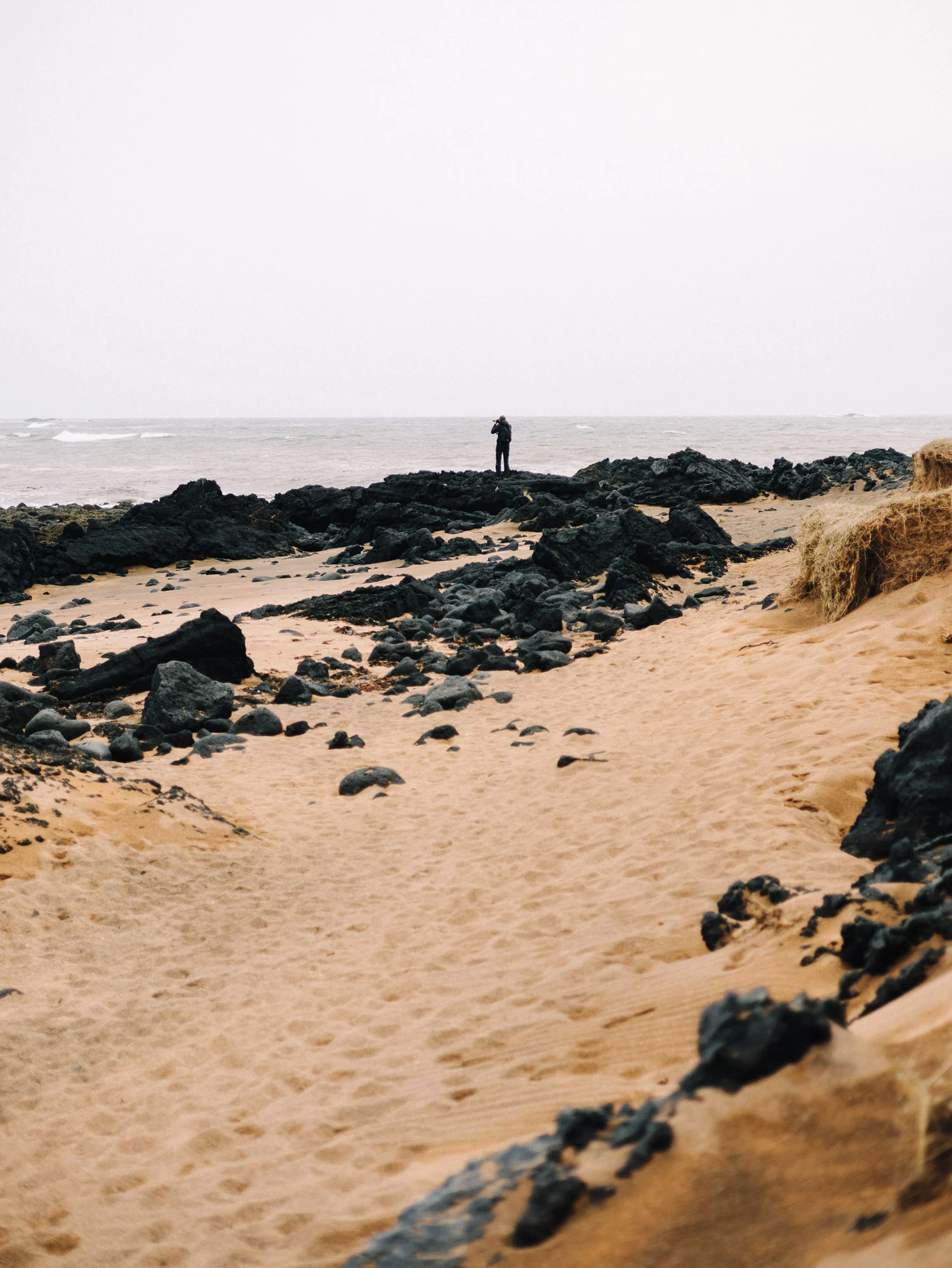 Promeneur sur les dunes et roches de lave de Stokksnes