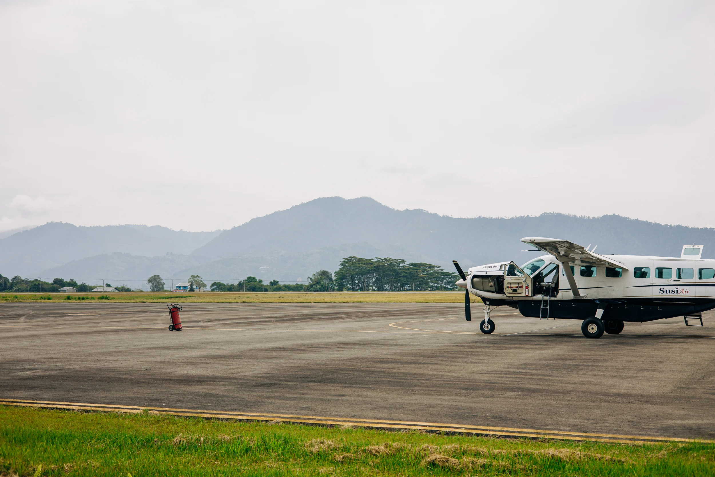 Avion sur la piste d'un aérodrome au pied des montagnes de Sumatra