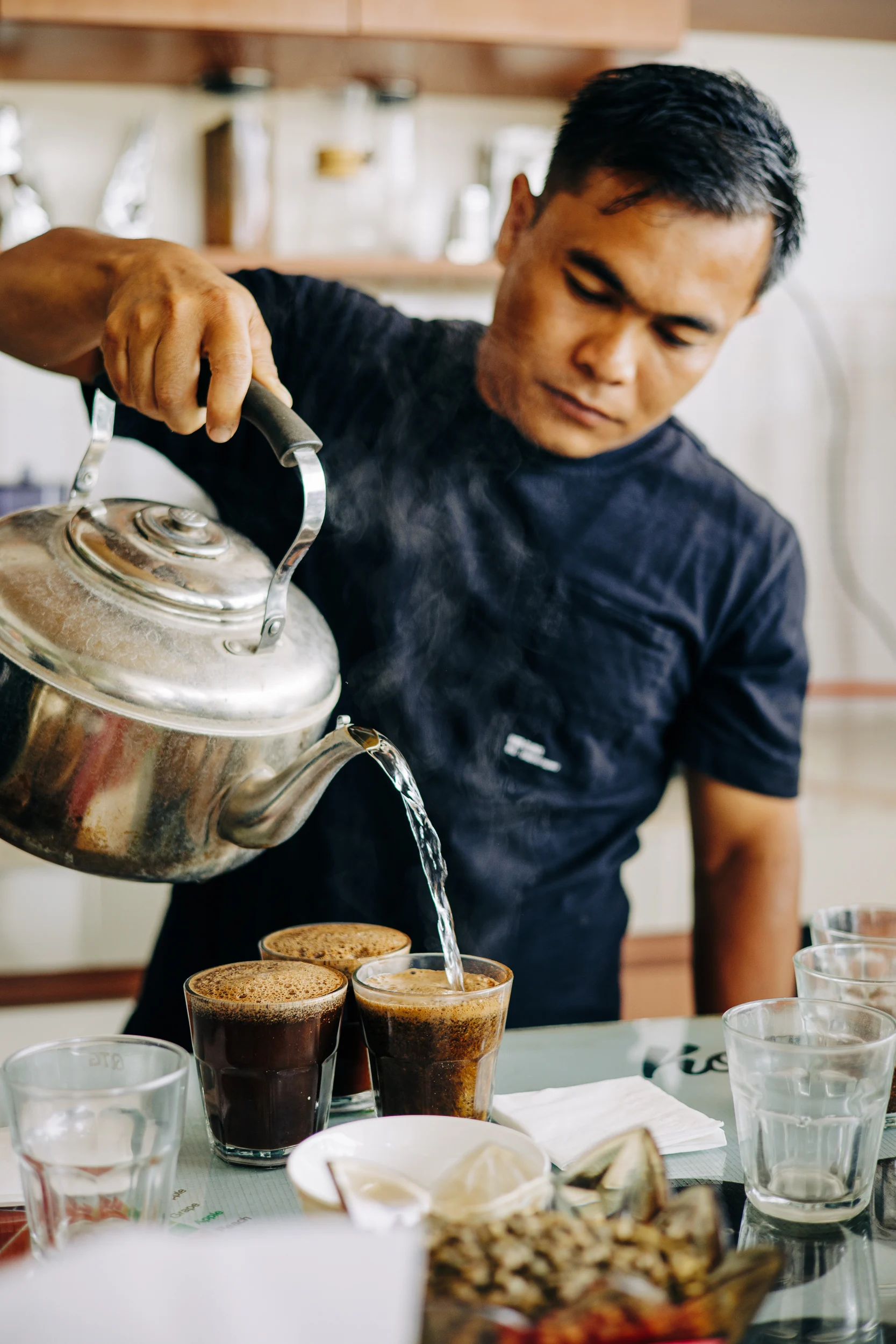 Dégustation de café : torréfacteur versant l'eau chaude dans les tasses