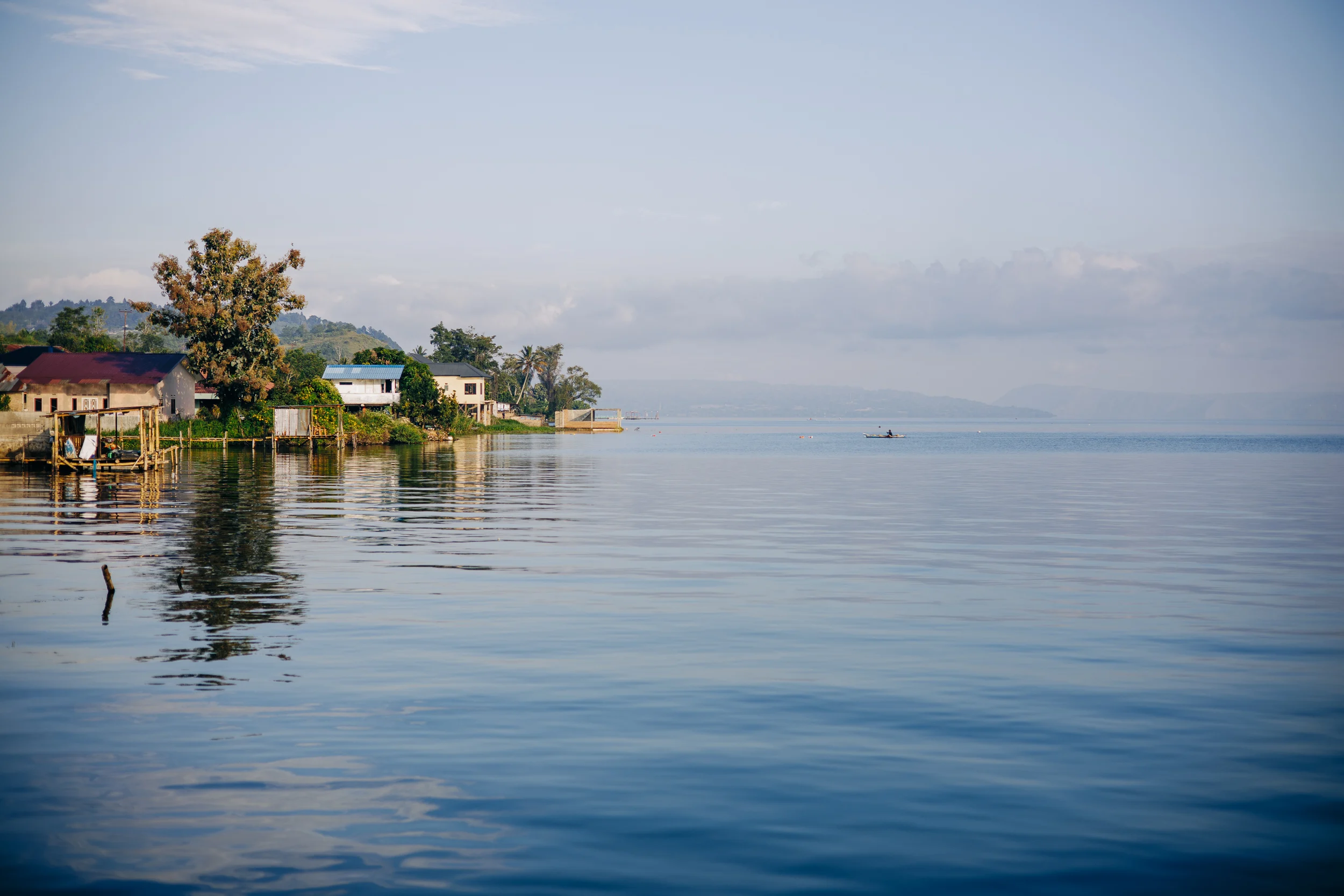 Maisons au bord d'un lac aux eaux calmes, Sumatra