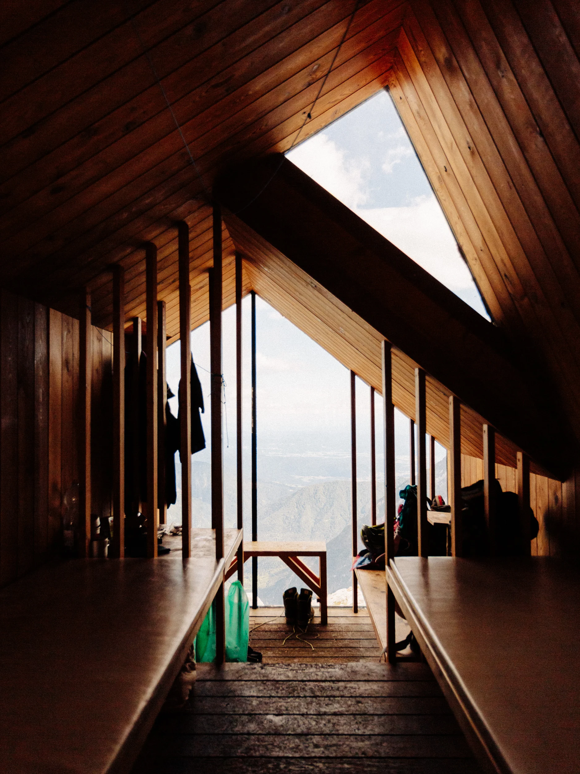 Intérieur en bois d'un bivouac de montagne ouvert sur les sommets