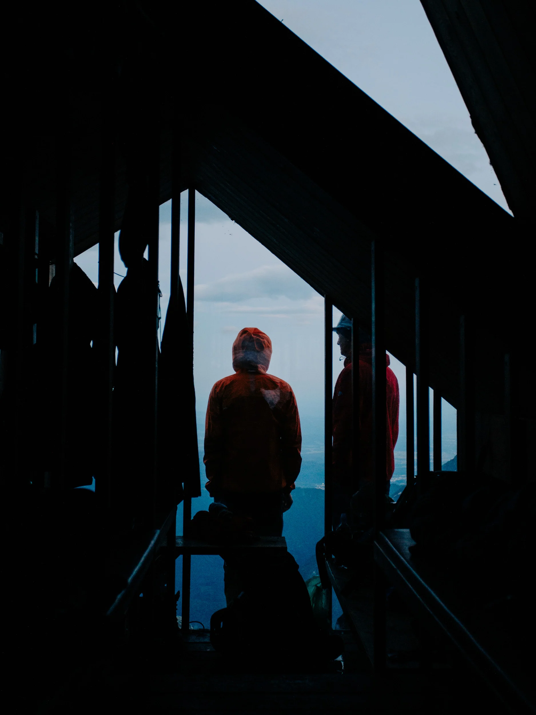Randonneurs en silhouette dans un refuge de montagne face au vide