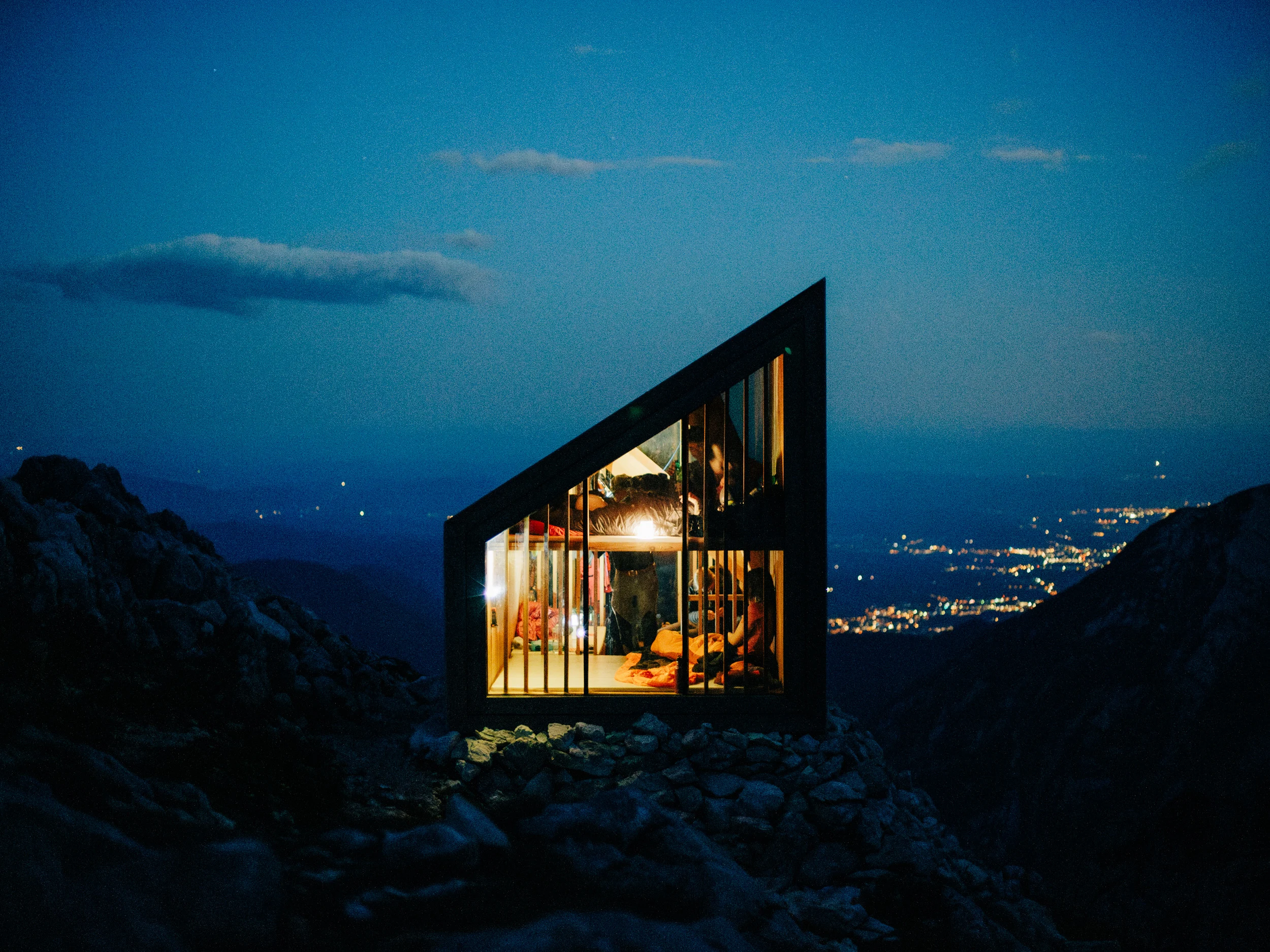 Bivouac moderne illuminé à la nuit tombée au-dessus de la vallée, Slovénie