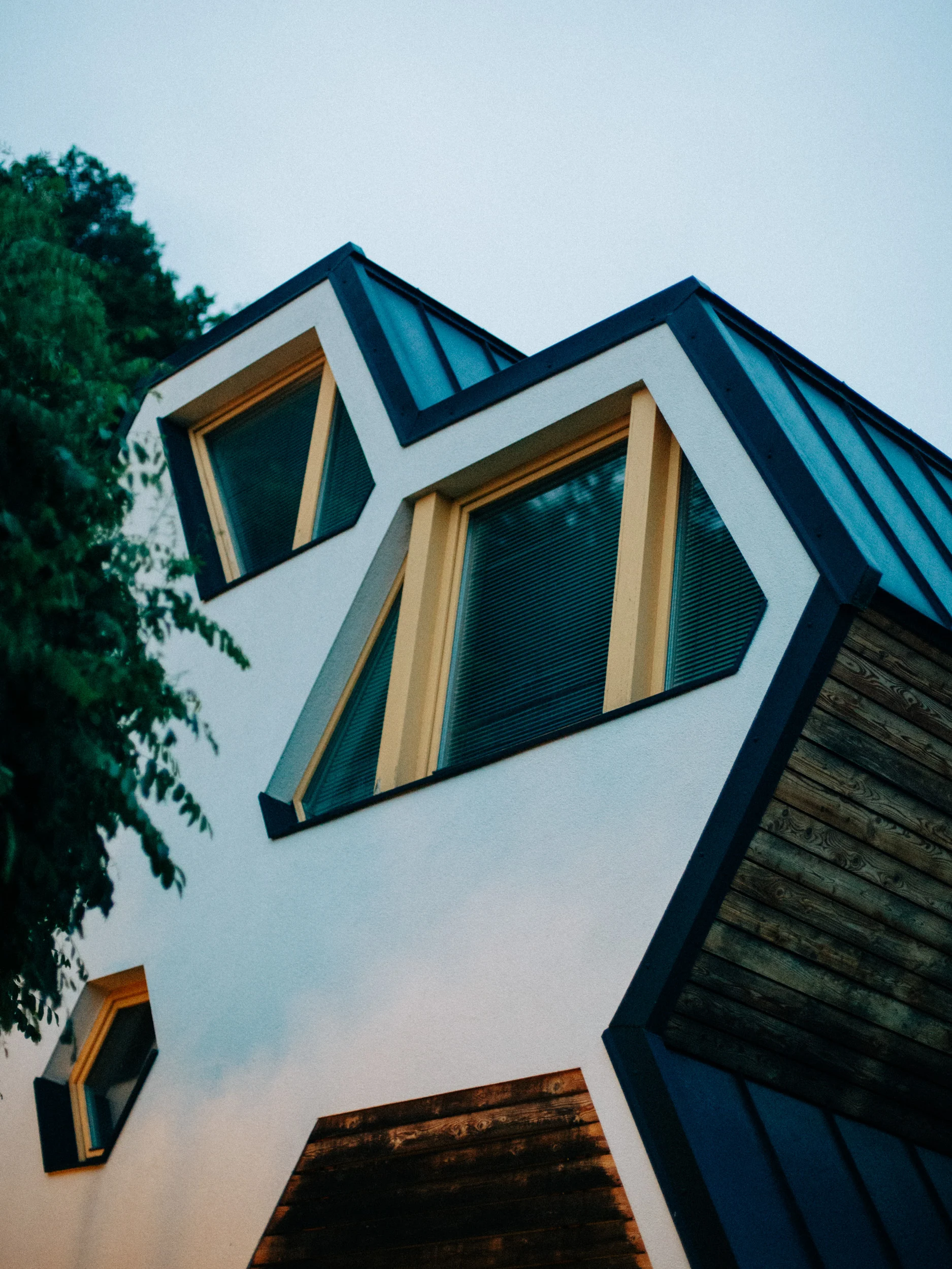 Façade aux fenêtres hexagonales d'une maison d'architecte en bois