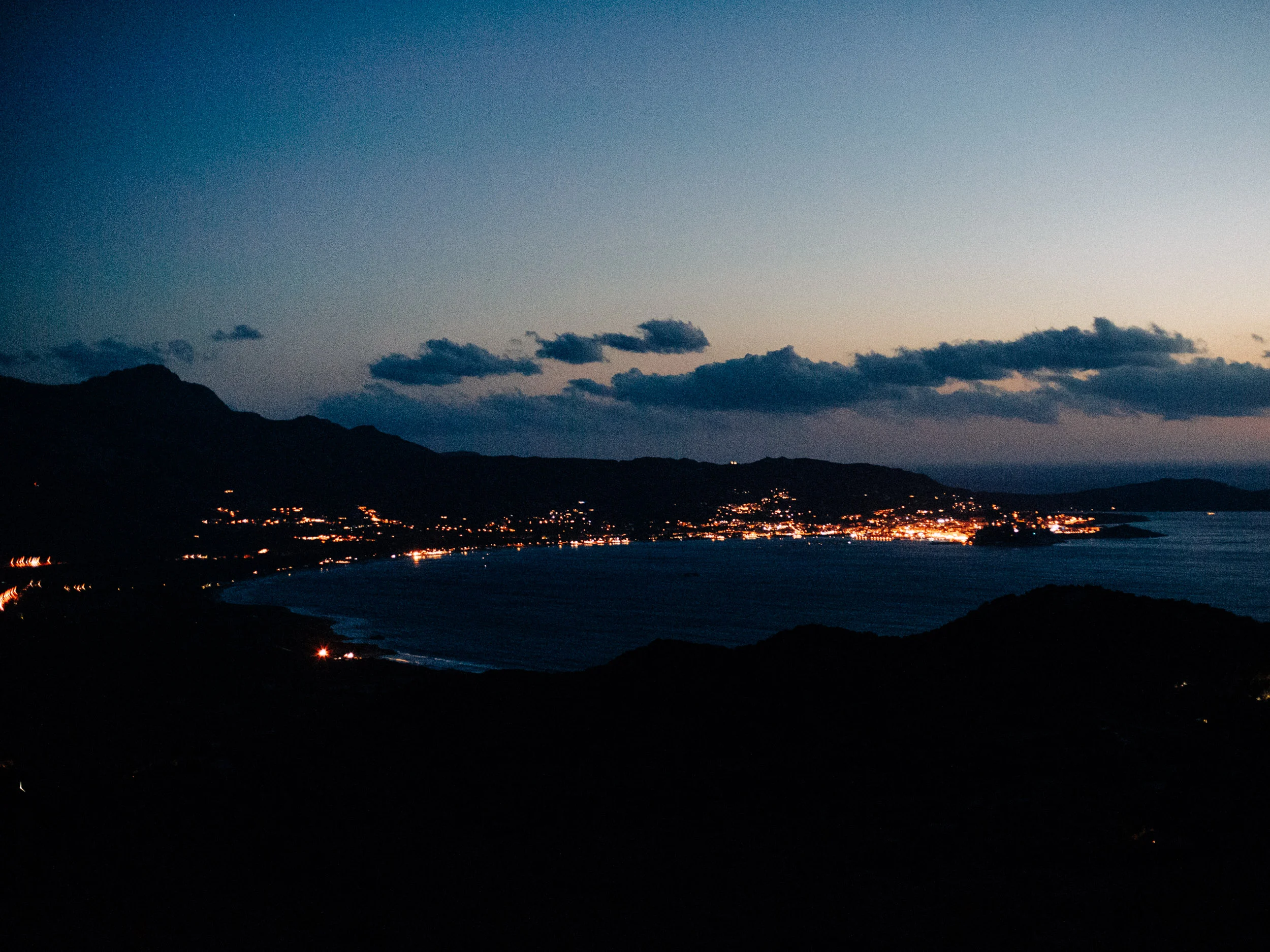 Lumières d'un village au bord du golfe à la tombée de la nuit, Corse
