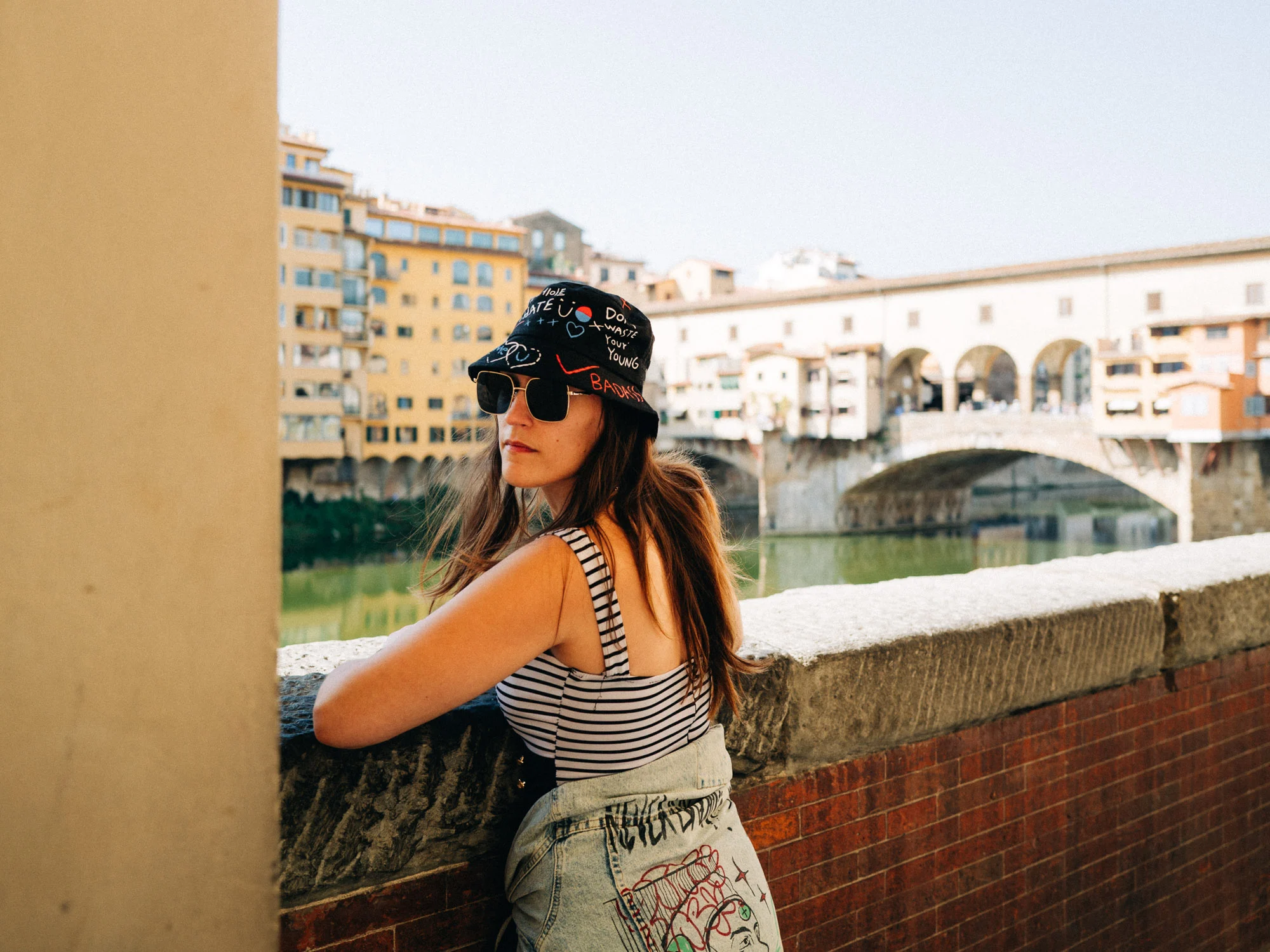 Voyageuse accoudée au parapet devant le Ponte Vecchio à Florence