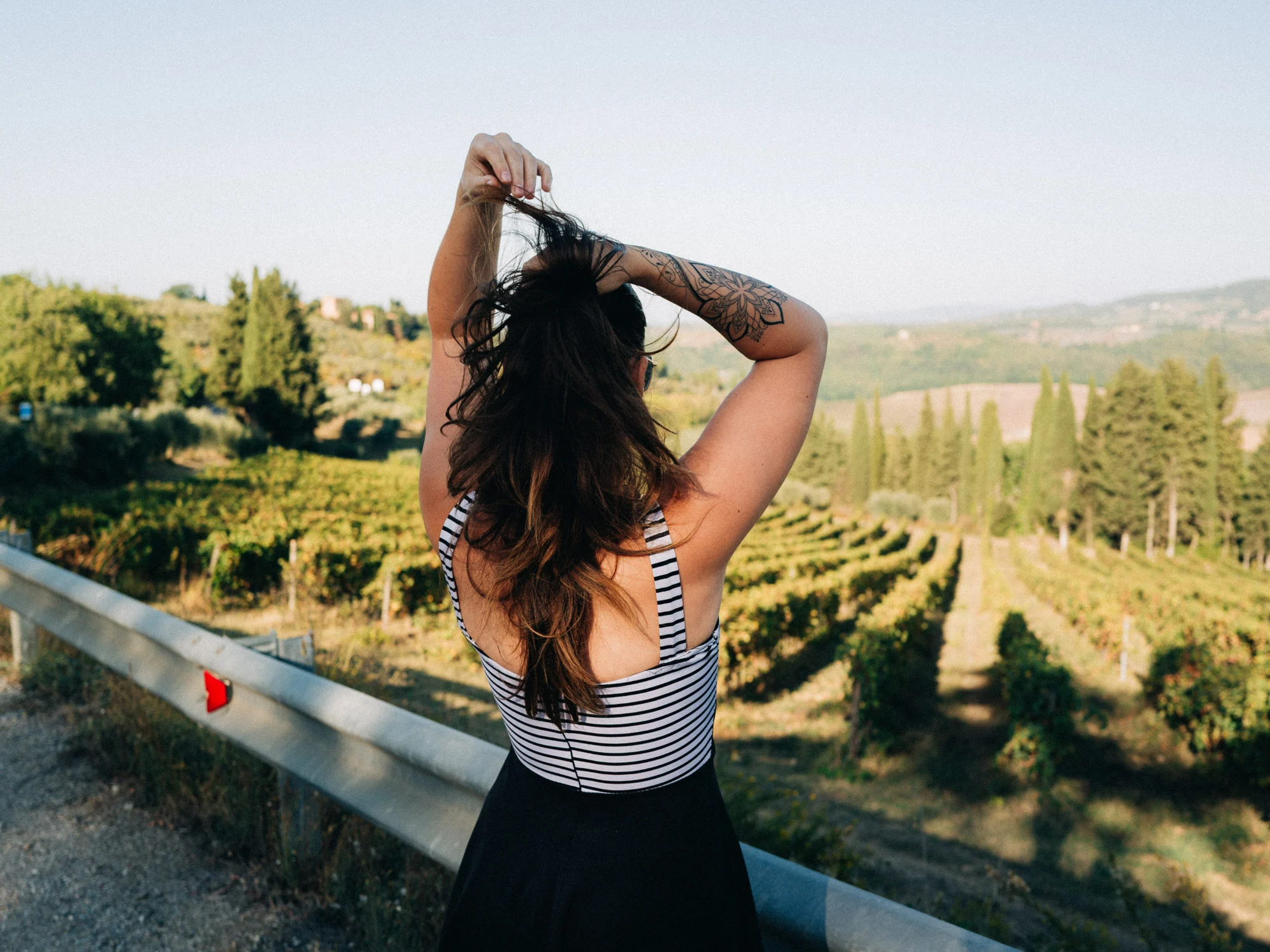 Femme de dos face aux vignes et aux collines de Toscane