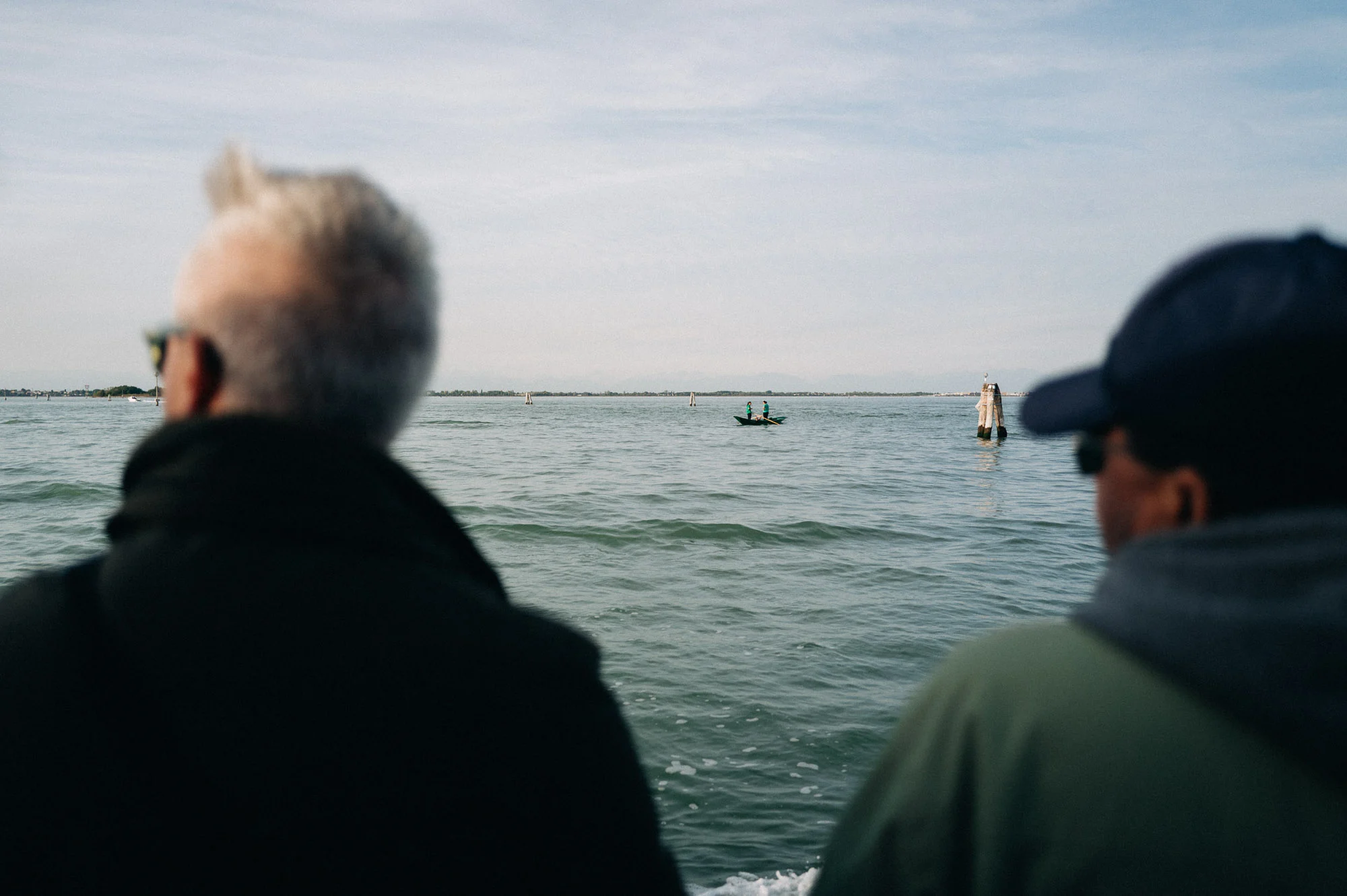 Deux passagers regardant l'horizon depuis un bateau sur la lagune