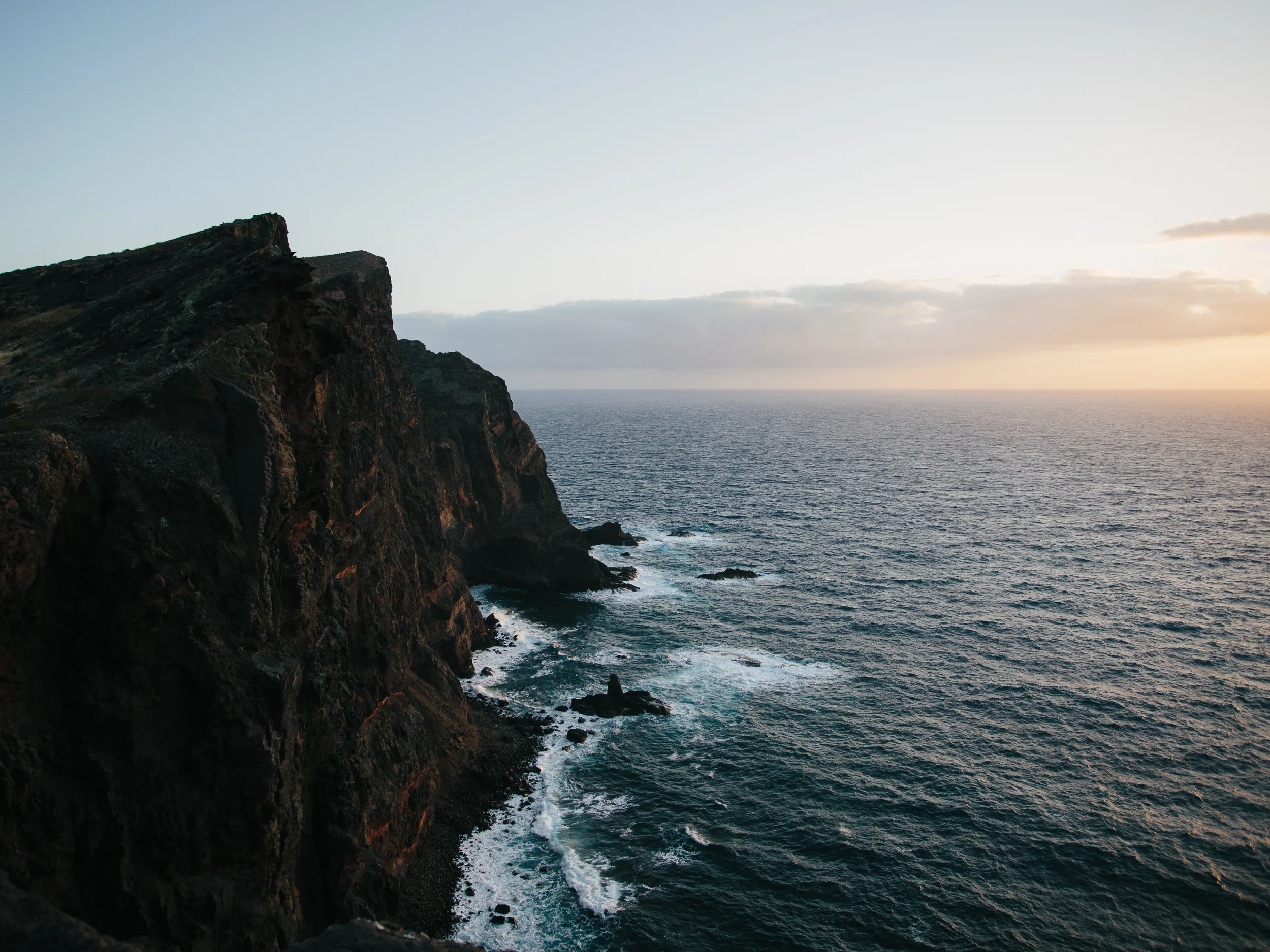 Falaises plongeant dans l'océan Atlantique au lever du soleil, île de Madère