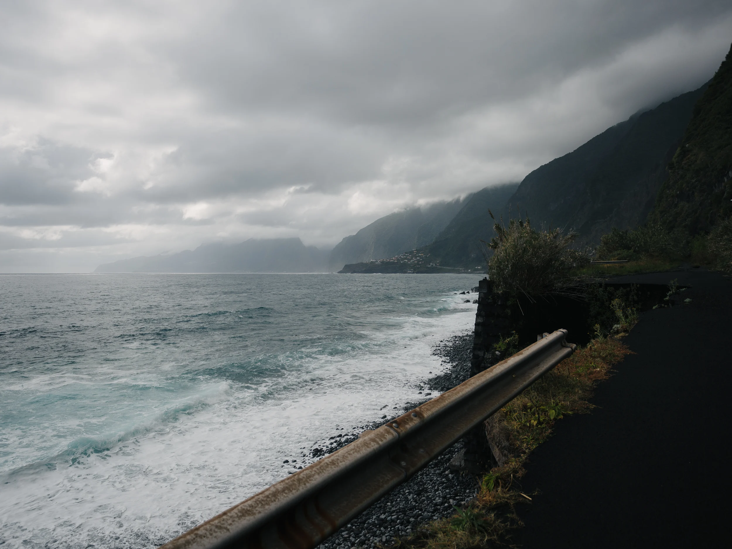 Route côtière au bord de l'océan agité sous un ciel d'orage, Madère