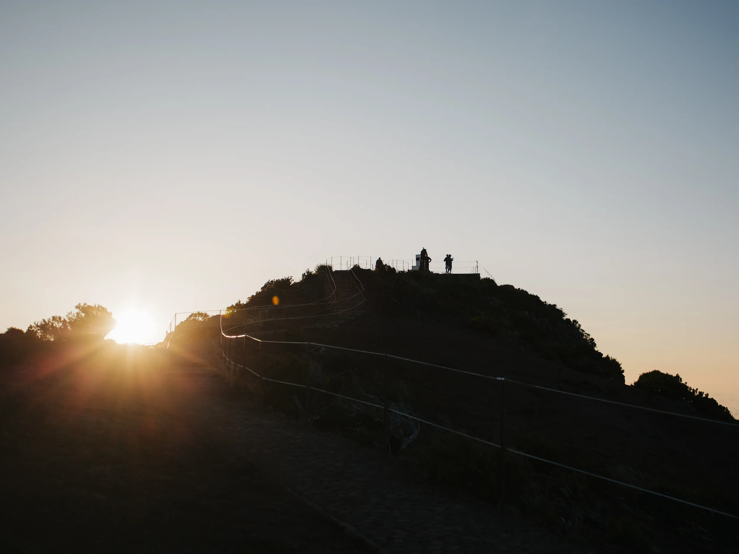 Randonneurs en silhouette au sommet au lever du soleil, Pico do Arieiro