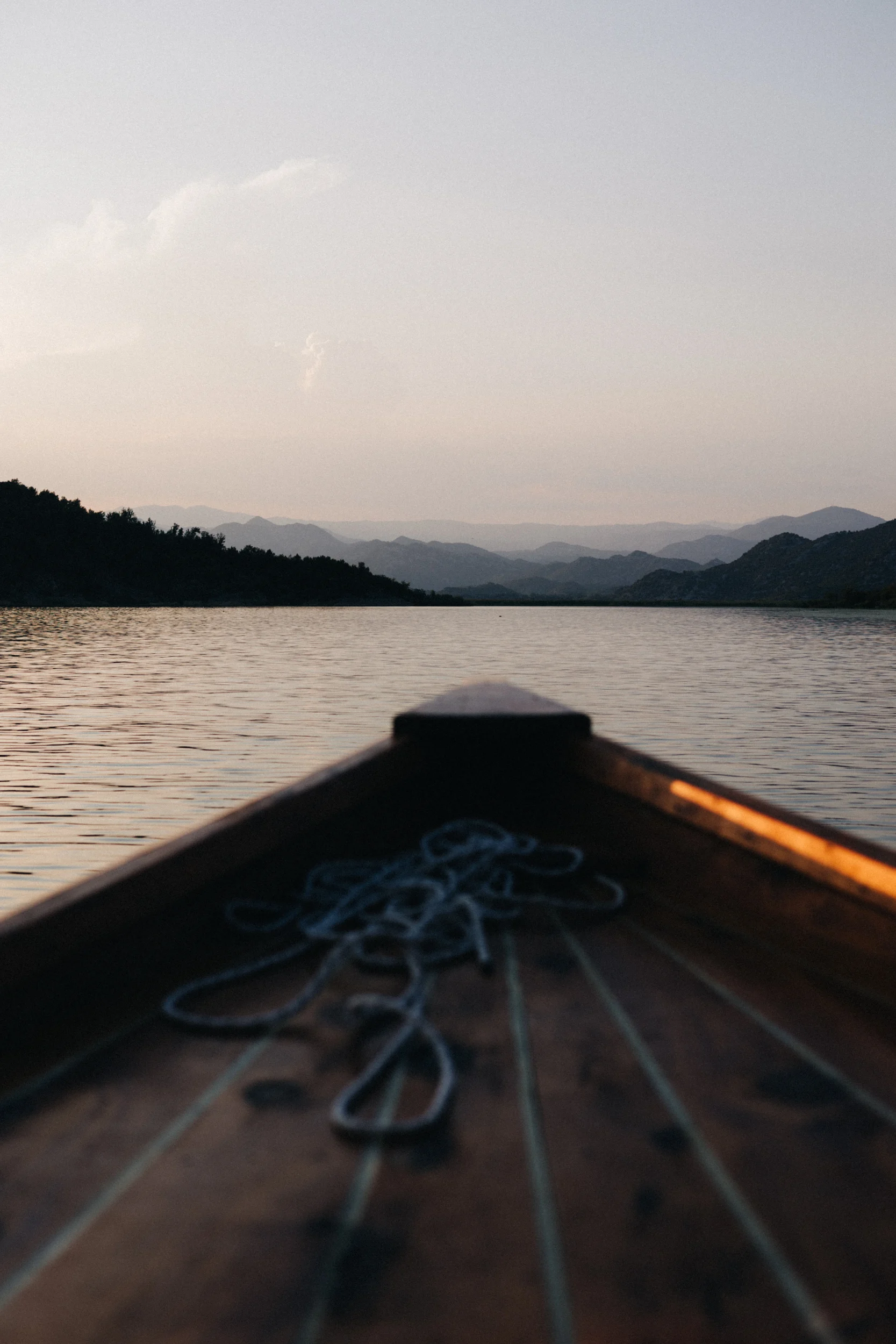 Proue d'un bateau en bois sur un lac au crépuscule