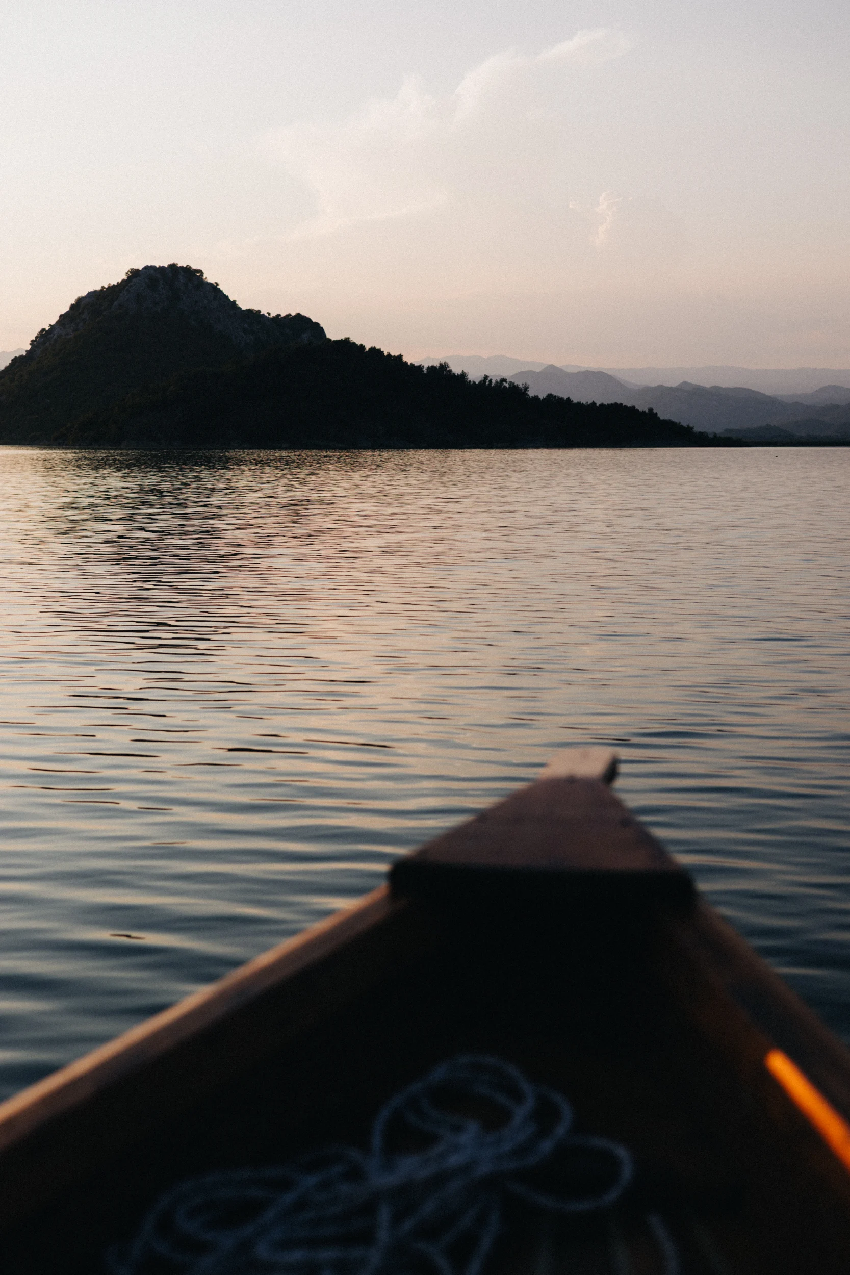 Proue d'une barque en bois glissant sur le lac au crépuscule, Monténégro
