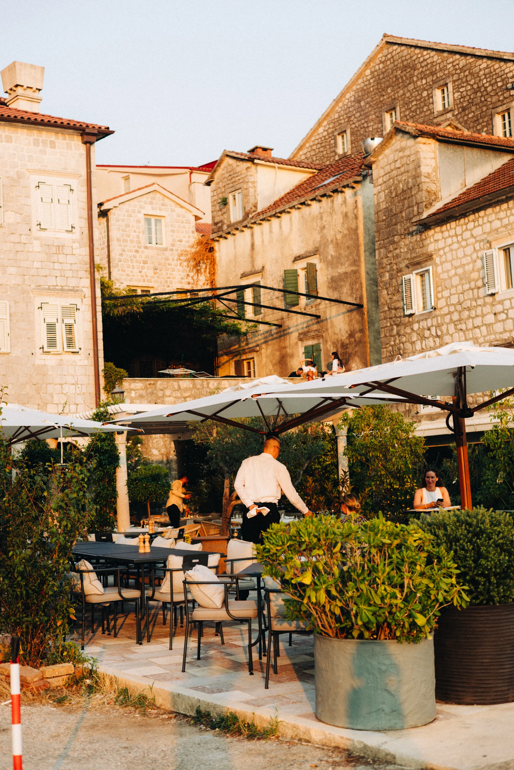 Terrasse de restaurant au pied des maisons en pierre de Perast